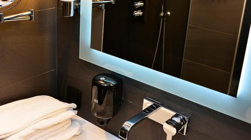 a bathroom with a sink and a mirror and towels at Hotel No13 in Bergen
