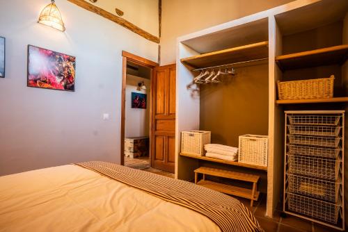 1 dormitorio con 1 cama y armario con cestas en El Cerro - El Cerro I, en Navarredonda de Gredos