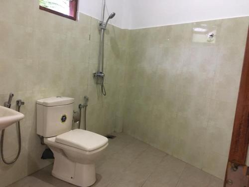 a bathroom with a toilet and a sink at Galle Fantacy in Unawatuna