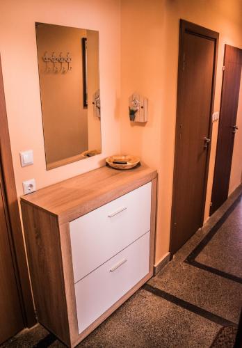a bathroom with a dresser with a mirror on the wall at Two Bedroom Apartment Downtown Ivanovi in Varna City