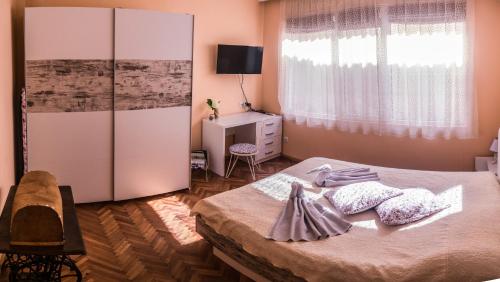 een slaapkamer met een bed, een dressoir en een raam bij Two Bedroom Apartment Downtown Ivanovi in Varna