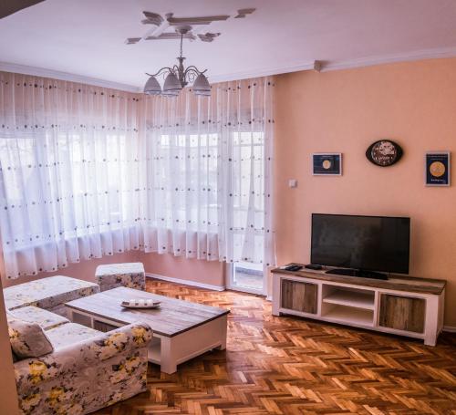 un soggiorno con un divano e una TV di Two Bedroom Apartment Downtown Ivanovi a Varna