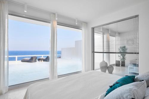 フィラにあるInfinite Blue Luxury Suitesの白いベッドルーム1室(海の景色を望む)