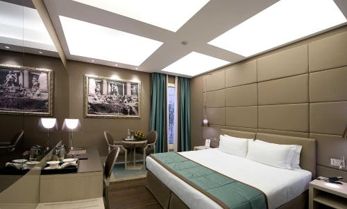 a hotel room with a bed and a desk at Harry's Bar Trevi Hotel & Restaurant in Rome