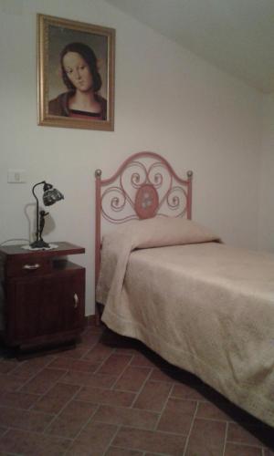 a bedroom with a bed and a picture on the wall at Il Castello in Monte Cerignone