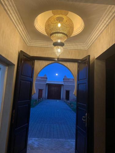 an open door with a chandelier and a hallway at Villa Diaf Johanne in Aït Ourir