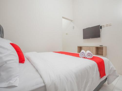a bedroom with a bed with two towels on it at RedDoorz near Ciputra Golf Surabaya in Surabaya