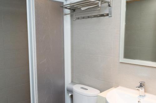 a bathroom with a toilet and a sink and a mirror at Bowa Hotel Penghu in Magong