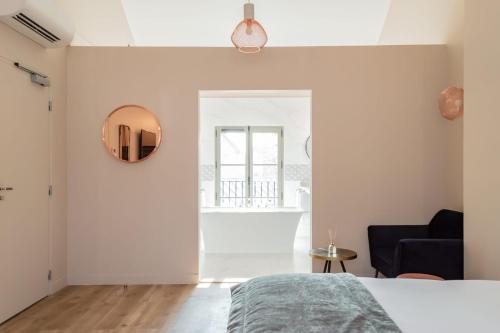 a bedroom with a bed and a mirror on the wall at Hotel des Iris in Auvers-sur-Oise