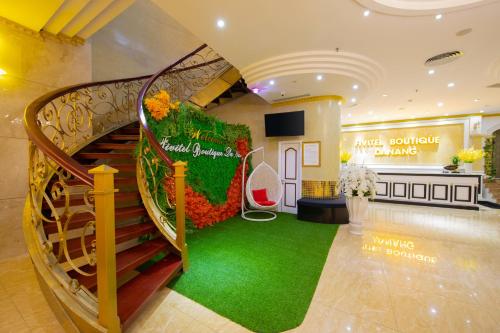 a lobby with a spiral staircase and a green carpet at Fivitel Boutique Da Nang in Da Nang