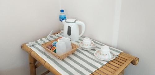 a table with a tea kettle and two cups on it at Numhom Resort in Ban Nong Chum Saeng