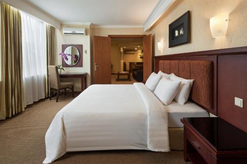 een hotelkamer met een groot bed en een bureau bij Golden Boutique Hotel Kemayoran in Jakarta
