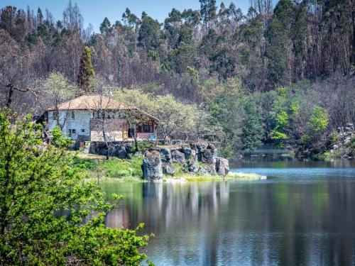 a house on a island in the middle of a lake at Traditional Mansion in Treixedo with Swimming Pool in Treixedo
