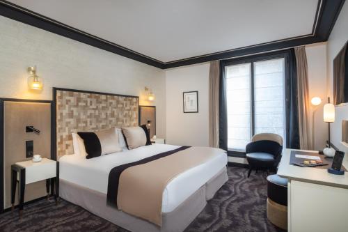 a hotel room with a bed and a desk at Hôtel le Derby Alma by Inwood Hotels in Paris