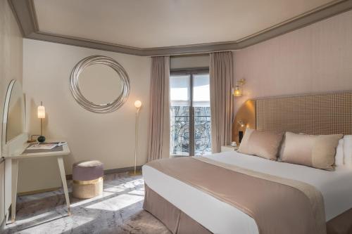 a bedroom with a large bed and a large window at Hôtel le Derby Alma by Inwood Hotels in Paris