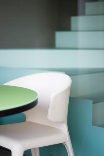 a white chair sitting next to a white table at UNA HOTELS T Hotel Cagliari in Cagliari