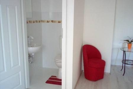 a bathroom with a red chair and a toilet at Rebeka Villa in Zamárdi