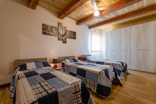 three beds in a room with wooden ceilings and wooden floors at Entire Villa - Gemini Farmhouse, Nadur Gozo in Nadur