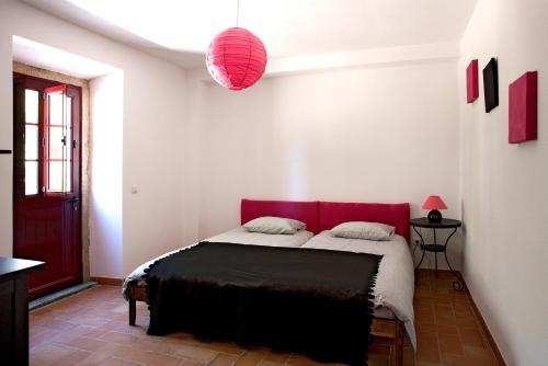 a bedroom with a bed with a red headboard at Quinta dos Álamos Agroturismo in Golegã