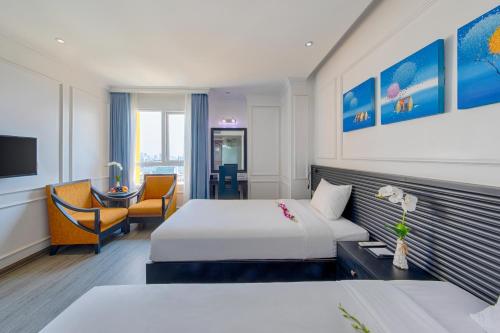 a hotel room with a bed and a desk at Fivitel Boutique Da Nang in Da Nang