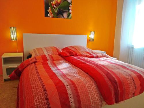 a bedroom with a bed with an orange wall at Living in the historic Cochem Old Town in Cochem