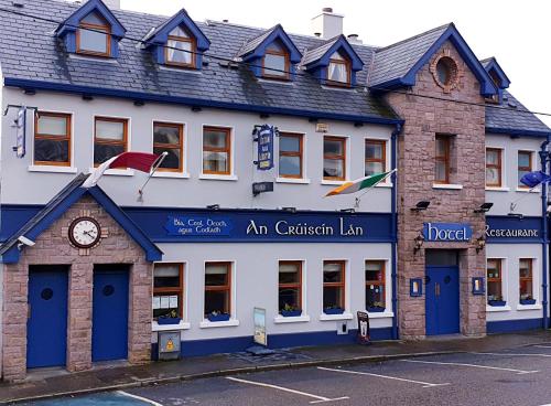 a building with a clock on the front of it at An Cruiscin Lan in Spiddal
