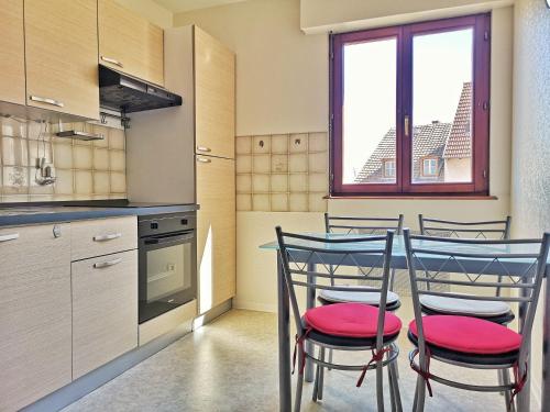une cuisine avec une table et quatre chaises dans l'établissement Chez Charlie - Centre ville Colmar - 2 pièces, à Colmar