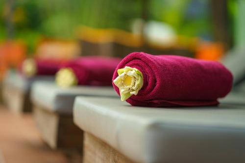 una toalla rosa con una flor en una mesa en Reveal Courtyard in Reveal Angkor, en Siem Reap