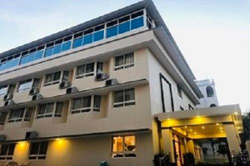 a large white building with a lot of windows at Sreeparthi Hotel in Puttaparthi