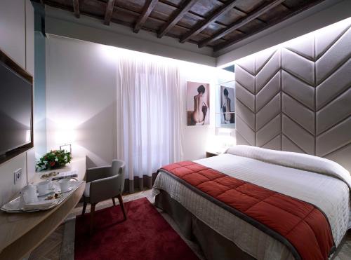 Pokój hotelowy z łóżkiem i biurkiem oraz łóżkiem o wymiarach sześciu sześciu sześciu. w obiekcie Harry's Bar Trevi Luxury Apartments - Modelli w Rzymie