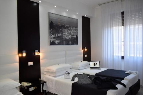 a bedroom with two beds and a picture on the wall at Hotel Perugino in Milan