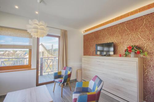 a living room with a table and chairs and a tv at Vila Nikolas in Druskininkai