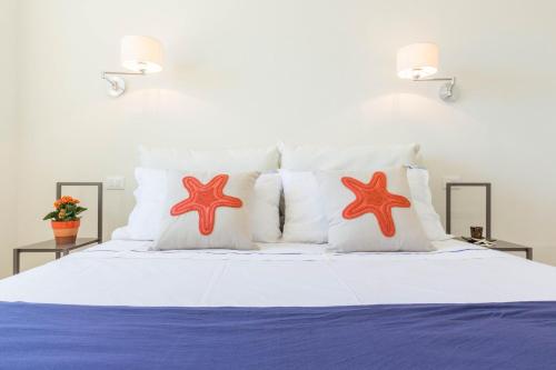ein Bett mit zwei Seestern-Kissen darauf in der Unterkunft Blue Apartment IUN S0079 in Cala Gonone