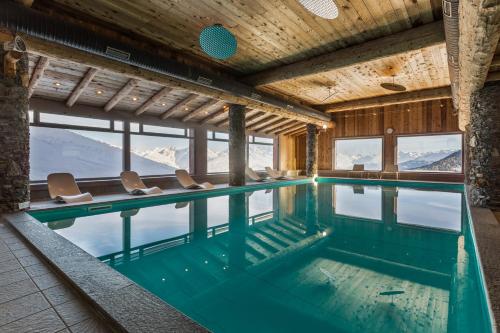 uma piscina com vista para as montanhas em Résidence Pierre & Vacances Premium Les Hauts Bois em Aime La Plagne