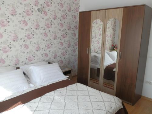 a bedroom with a bed and a cabinet with mirrors at Garsoniera Luxury in Sibiu