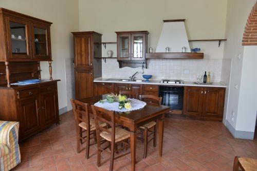 a kitchen with a wooden table with chairs and a sink at Agriturismo Musignano in Cerreto Guidi