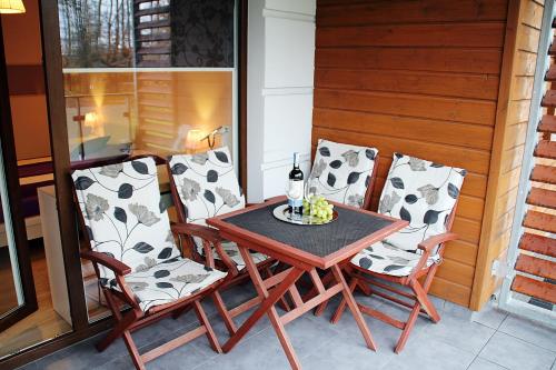 einen Tisch und vier Stühle auf einer Veranda in der Unterkunft Apartament POLANKI in Kołobrzeg