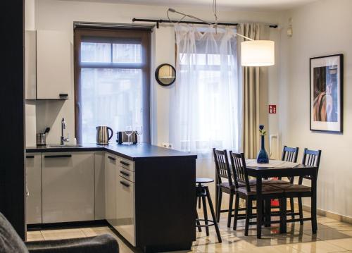 een keuken en eetkamer met een tafel en stoelen bij Kaunas Old Town Apartment in Kaunas
