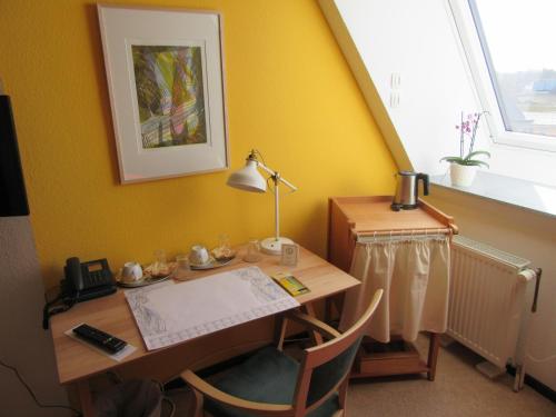 ein Büro mit einem Schreibtisch mit einer Lampe und einem Tisch mit Stühlen in der Unterkunft Haus Aja Textor-Goethe in Frankfurt am Main