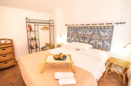 una camera da letto con un letto e un vassoio di frutta; di Homey Experience - Attic Sea View Apartment a La Maddalena