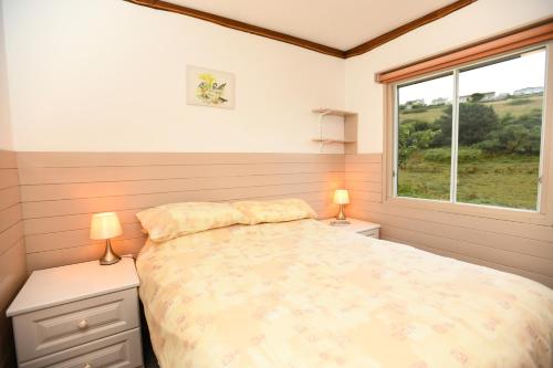 a bedroom with a bed and a window in it at Churchwood Valley in Plymouth