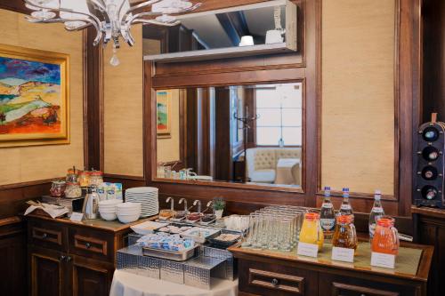 a room with a counter with a mirror and a table with drinks at Hotel Meridian in Cluj-Napoca