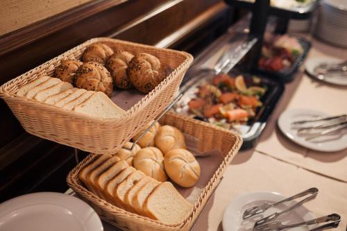 two baskets filled with bread and pastries on a table at Hotel Meridian in Cluj-Napoca