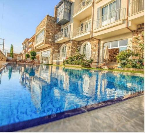 una grande piscina di fronte a un edificio di Vinifera Ephesus Hotel a Selçuk