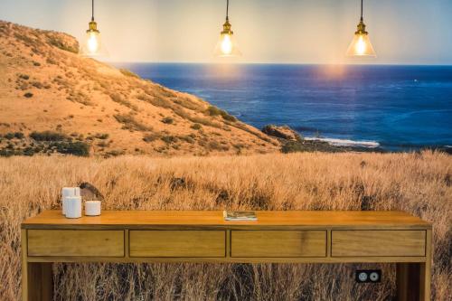 a dresser with a painting of the ocean at L'Appart du Tropiclub - bien-être à 2 pas du lagon in Filaos