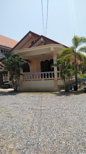 a house with a gravel yard in front of it at บ้านพักน้องจ็อบ in Baanphakrimlay 