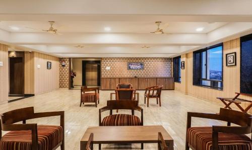 a waiting room with chairs and tables and windows at Shri Vitthal Mangalam Satara in Satara