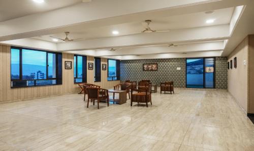 a dining room with a table and chairs and windows at Shri Vitthal Mangalam Satara in Satara