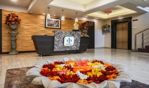 a lobby with a large flower arrangement on the floor at Shri Vitthal Mangalam Satara in Satara
