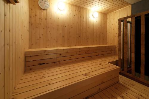 a wooden sauna with a clock on the wall at Tsubakikan in Aomori
